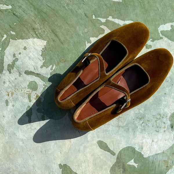 Le Monde Béryl velvet mary janes in tobacco on a green background